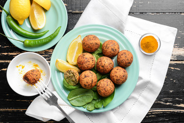 Tasty falafel balls with sauce on wooden table