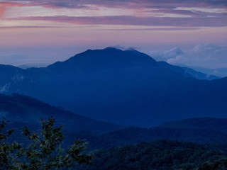 sunrise at Doi Inthanon, mountain view misty morning of top hills around with sea of fog with cloudy sky background, KM.41 View Point Doi Inthanon, Chiang Mai, Thailand.