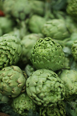 Close up of bunch of green artichokes at the organic supermarket vegetables department. Sustainable agriculture.