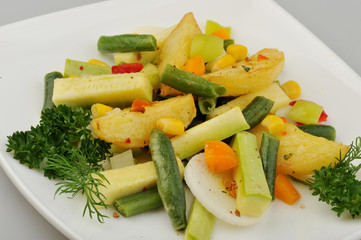 Different green vegetables on the plate gray background
