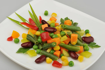 Different green vegetables on the plate gray background
