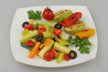 Different green vegetables on the plate gray background