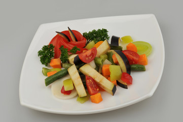 Different green vegetables on the plate gray background