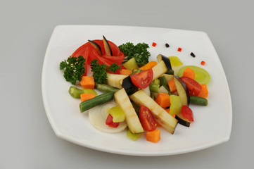 Different green vegetables on the plate gray background