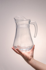hand holds a carafe for drinks on a white background. isolate