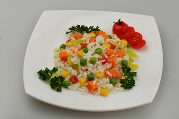 A plate of rice with vegetables on the gray background