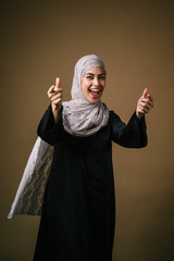 Portrait of a tall, slim and elegant Muslim Middle Eastern woman in a black dress and white hijab...
