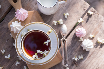 Fototapeta na wymiar still life - cups of tea, meringues and flowers