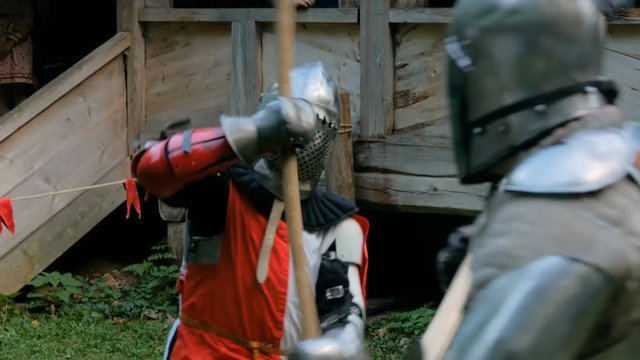 Two militant medieval knights fighting at historical festival. Fantasy, history, reenactment and medieval culture concept
