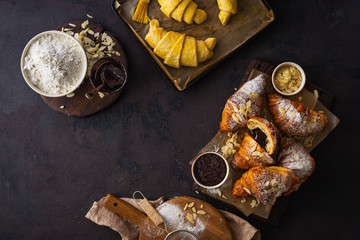 Breakfast croissant with chocolate on a dark stone background top view