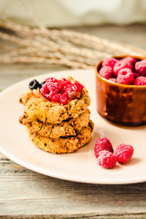 Homemade crunchy oatmeal cookies with raspberry jam and date caramel on a grey wooden background. Horizontal.
