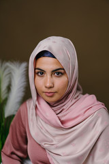 Close up studio head shot portrait of a beautiful, vital and attractive young Middle Eastern Muslim...
