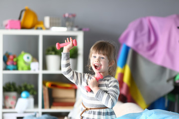 Cute little girl make physical exercises at home as motivation concept