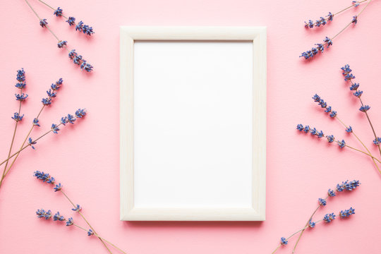 Dried purple lavender with blank white photo frame on pastel pink background. Mockup for positive idea. Empty place for inspirational, emotional, sentimental text, quote, sayings or picture. Flat lay.