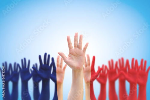 France national flag pattern on people palm hands raising up on blue sky background