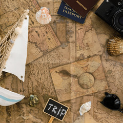 Travel background.Travel passports, vintage camera, seashells, starfish, boat against  old map.Vacation concept.Top view