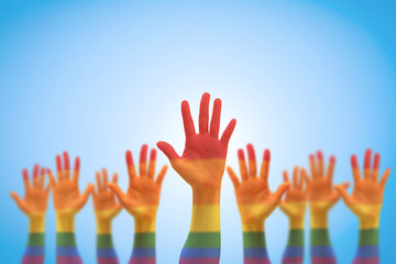 LGBT equal rights movement and gender equality concept with rainbow flag on people's hands up