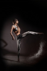 Girl dansing with flour on black background one person