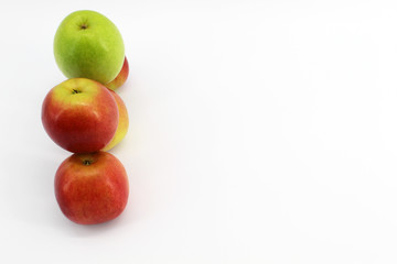 One green Apple and four red apples. White background