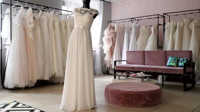 Many wedding dresses on the hangers in modern interior salon. Wedding shop interior