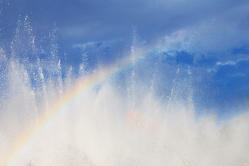fountain with a rainbow against the blue sky
