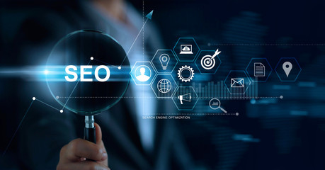 SEO Search Engine Optimization Marketing concept. Businessman with magnifying glass in hand searching on website and network. Digital online marketing. Business Technology.