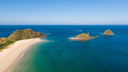 Wide tropical beach with white sand and small islands, top view. Nacpan Beach El Nido, Palawan. Seascape in clear weather, view from above.