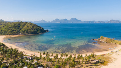 Small sea bay with a white beach, view from above. Settlements and nature in the Philippine Islands.