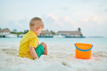 Three year old toddler playing on beach