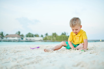 Three year old toddler playing on beach