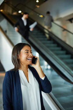 Joyful Excited Young Black Woman Standing At Escalator And Laughing Loudly While Talking On Mobile Phone 