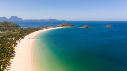 Fototapeta na wymiar Wide tropical beach with white sand and small islands, top view. Nacpan Beach El Nido, Palawan. Seascape in clear weather, view from above.
