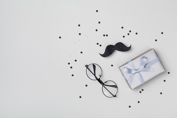 Gift or present box, moustache, glasses and confetti for Happy Father day. Top view and flat lay.