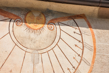 Fototapeta na wymiar A detail of the old sundial painted on 1465 over the external wall of the little chapel of St. Magdalena in Val di Funes