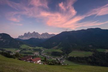 Small Italian mountain town of St. Magdalena in Val di Funes at sunset