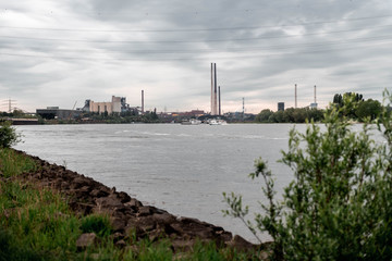 Obraz premium NRW/GERMANY - MAY 16, 2019: View of the industrial area with production plants next to the river rhine in Duisburg, Germany.