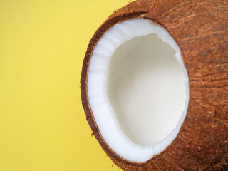 Close up of open coconut on yellow background, macro of coconut texture, space for text