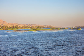 A island in the Nile with distant cruise ships passing Ezbet El-Gawad