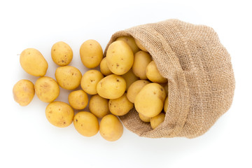 Sack of fresh raw potatoes on wooden background, top view