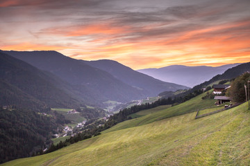 Small Italian mountain town of St. Magdalena in Val di Funes at sunset