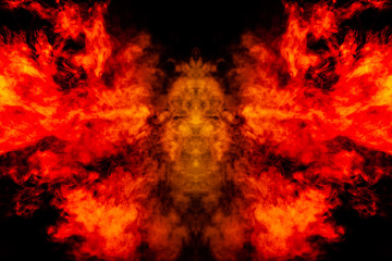 Fototapeta na wymiar Smoke of different orange and red colors in the form of horror in the shape of the head, face and eye with wings on a black isolated background. Soul and ghost in mystical symbol