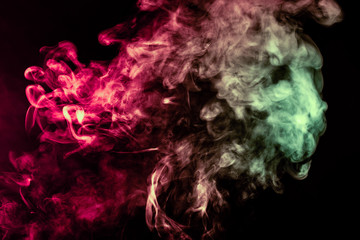 Beautiful column of smoke in the neon bright light of red, green, pink and turquoise on a black background exhaled out of the vape. Nice pattern for printing and backdrop of colored waves.