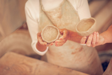 Top view of a clay bowl in female hands