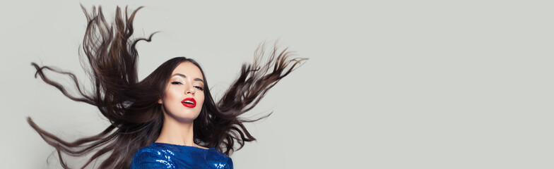 Beautiful woman with long healthy blowing hair on white