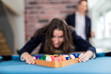 Young modern woman preparing pool balls for the next snooker game.