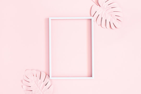 Summer composition. Tropical palm leaves, photo frame on pink background. Summer concept. Flat lay, top view, copy space