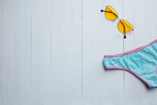 Yellow sunglasses on the white wooden bakground.