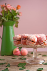 Arrangement of peaches shaped homemade cookies with flower on the vintage background.