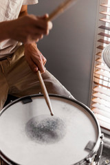 Drummer playing rock beat using snare drum & high-hats.