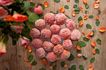 Arrangement of peaches shaped homemade cookies with flower on the vintage background.